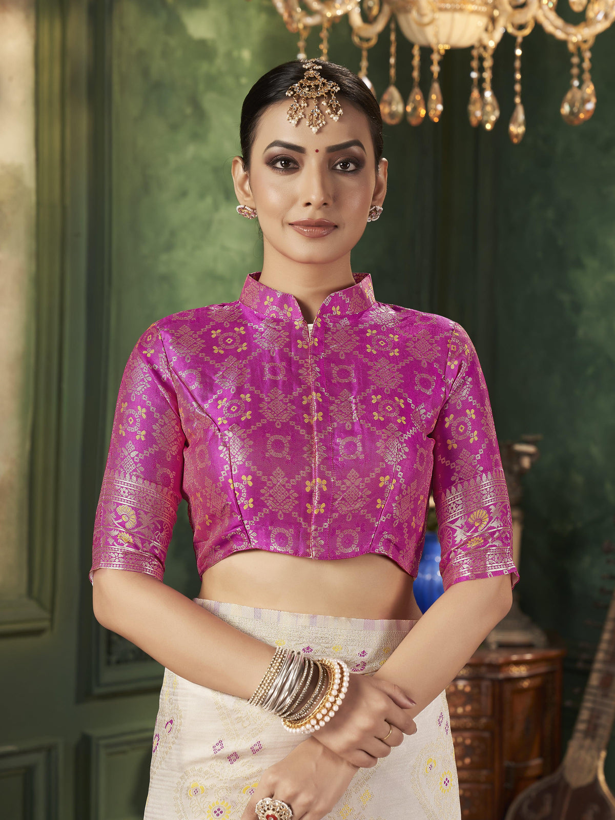Woman in magenta pink blouse with silk saree, festive wear.